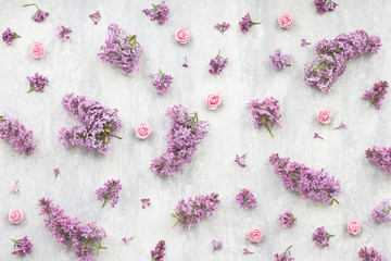 Pink rose and lilac flowers on grey background, flat lay, top view