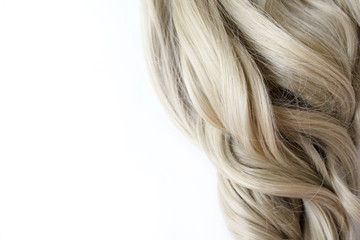 Naklejka premium Beautiful wavy hair. Light brown hair. Hair is gathered in a bun on a white background. With free space for text. For a poster or business card.