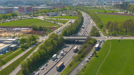 DRONE: Countless vehicles form a traffic jam on the highway near a modern city.