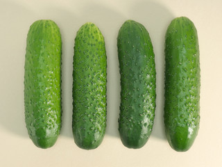 Four green cucumber on beige background