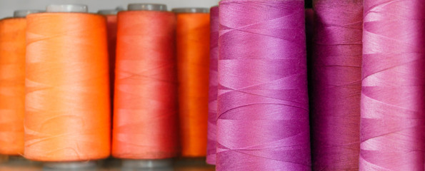 background - bobbins of blue and purple threads