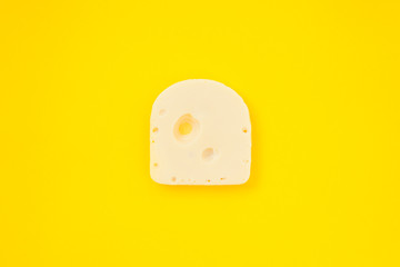 Piece of cheese on yellow color background