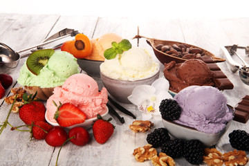 ice cream scoops of different colors and flavours with berries, nuts and fruits decoration on white background
