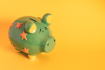 Green piggy bank on yellow background