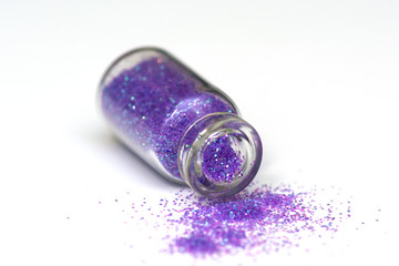 Glitter nail and make-up colorful in glass bottles on white background.
