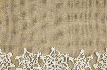 Minimalist brown embroidery cotton fabric with crochet snowflakes. Vintage Christmas border frame concept.
