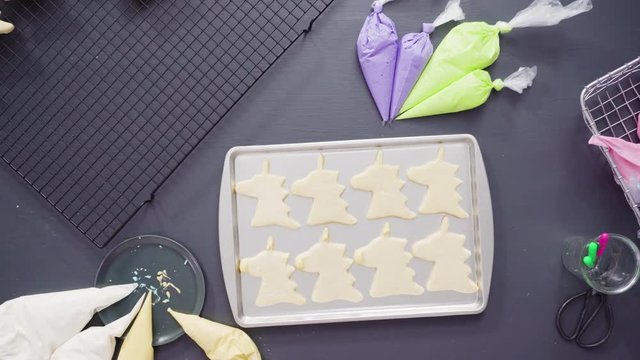 Flat lay. Decorating unicorn sugar cookies with multi-color royal icing.