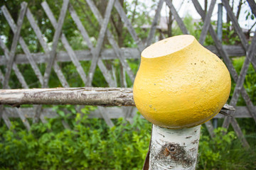 yellow cast iron pot on the fence in the village garden