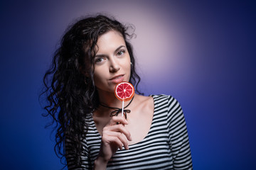 studio shot of dark hair woman with delicious candy
