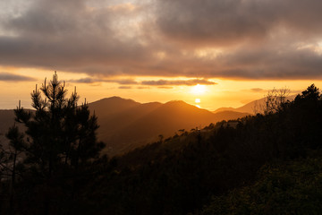 Dramatischer Sonnenuntergang im Meer vor Bergkulisse