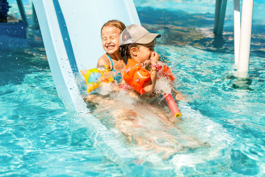 Child On Water Slide At Aquapark. Summer Holiday.
