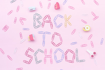 colored paper clips on a pink background lined with the inscription - back to school.