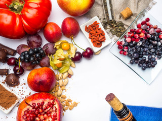 food rich with resveratrol, grapes, pomegranate, green tea on sackcloth, physalis, cranberry, cherry, tomatoes, goji, peanuts, blueberry dark chocolate, cocoa, red wine