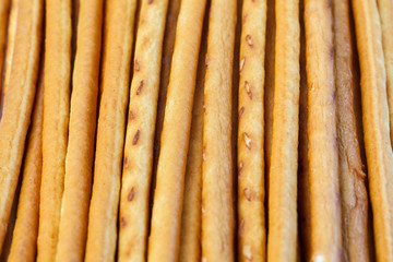 Salty or sweet straw from dough, snack from crackers, crispy breadsticks, close-up background