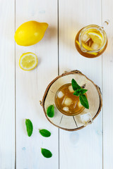 Kombucha tea with lemon, ice and mint on a wooden table. Probiotic food.