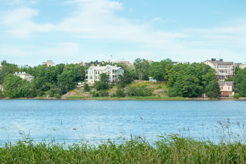 Toolo Bay in City Park, Helsinki, Finland. Across the water, rides at Linnamaki amusement park can be seen above the trees.
