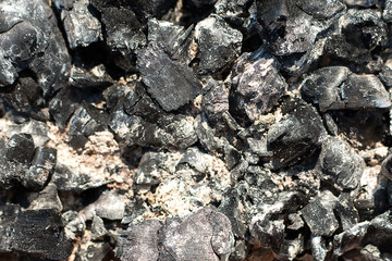 Coals in an extinct fire. Natural background. Remains of wood coal and ashes after the combustion of firewood