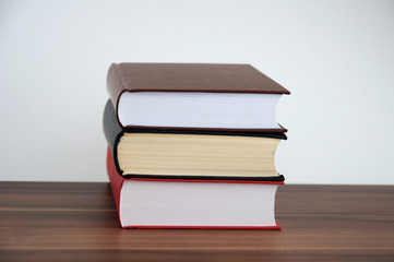 A stack of books on a light background with a field for writing text or inscriptions