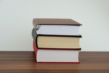 A stack of books on a light background with bookmarks to read