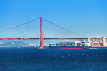 Cargo ship passing under Golden Gate Bridge, USA