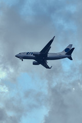 Aeroplane in the cloudy sky is flying from aeroport after summer rain.