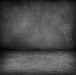 Empty grey concrete floor and blackboard wall