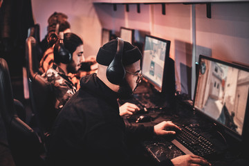 Serious friendly team have a game battle at cozy cyber club. © Fxquadro