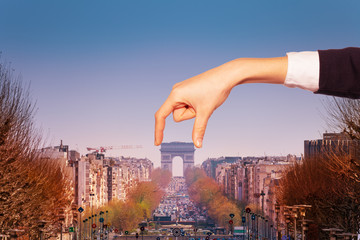 Optical illusion of hand holding Arc de Triumph