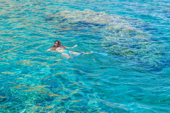 sexy girl swimming and snorkeling in Red sea beautiful aquamarine water exotic natural environment, enjoy in summer cruise vacation time concept picture with empty copy space for text