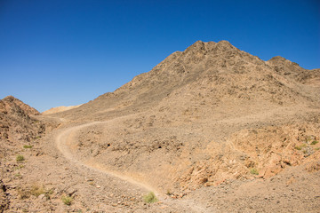dangerous trail through wilderness national conservation area of sharp rocky and dry sand stone desert mountain environment 