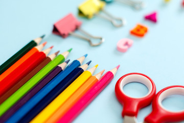 Fototapeta premium Collection of school supplies neatly stacked on a blue background.