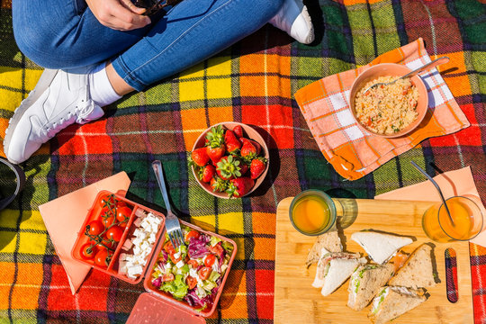 Young woman having a picnic with healthy food in a park