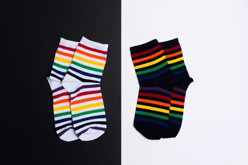 Two negative white and black background with two pair of socks with colorful striped pattern