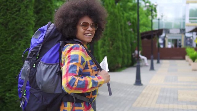 african woman tourist with an afro hairstyle rear view slow mo