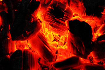 Background from a fire, firewoods and decaying red coals