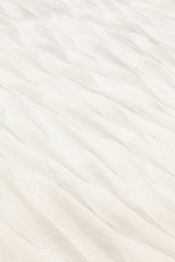 Fototapeta na wymiar Dark patterns on the white beach sand