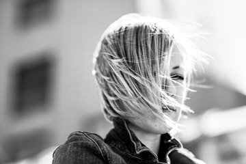Portrait of a girl with short hair. Blonde in the city. Black and white photography