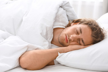 Fototapeta na wymiar Handsome young man sleeping on pillow. Bedtime
