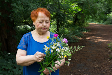 elderly woman park flowers hands bouquet