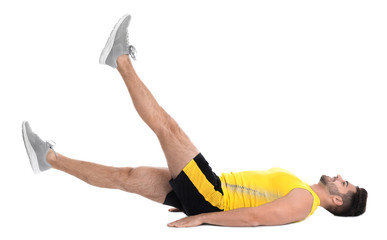 Handsome young man in sportswear doing scissors exercise on white background