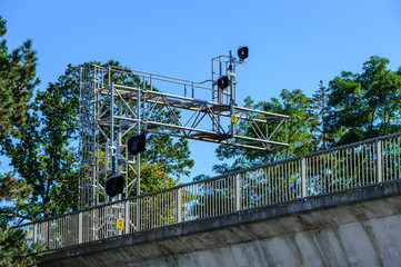 Fototapeta premium Train signals above bridge with fence.