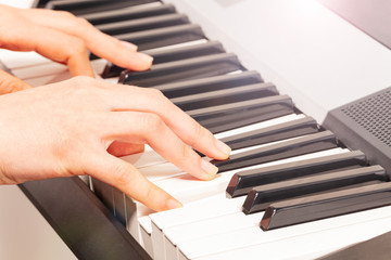 Close up of woman's hand playing digital piano