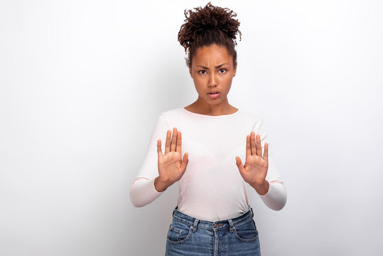 Pretty girl raised hands in s gesture in studio. Concept gesture - Image