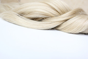 Beautiful wavy hair. Light brown hair. Hair is gathered in a bun on a white background. With free space for text. For a poster or business card.