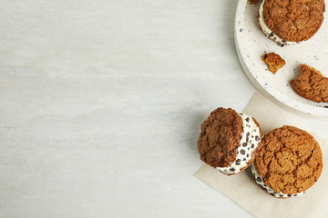 Sweet delicious ice cream cookie sandwiches on table, flat lay. Space for text