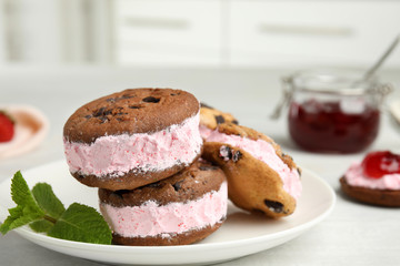 Plate with sweet delicious ice cream cookie sandwiches on table, space for text
