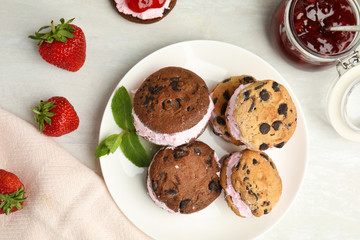 Sweet delicious ice cream cookie sandwiches served on table, flat lay