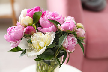 Vase with bouquet of beautiful peonies in room, closeup