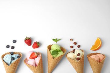 Composition with delicious ice creams in waffle cones on white background, top view