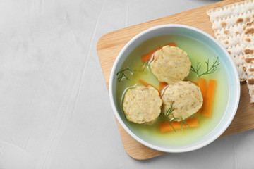 Flat lay composition with Jewish matzoh balls soup on light table. Space for text